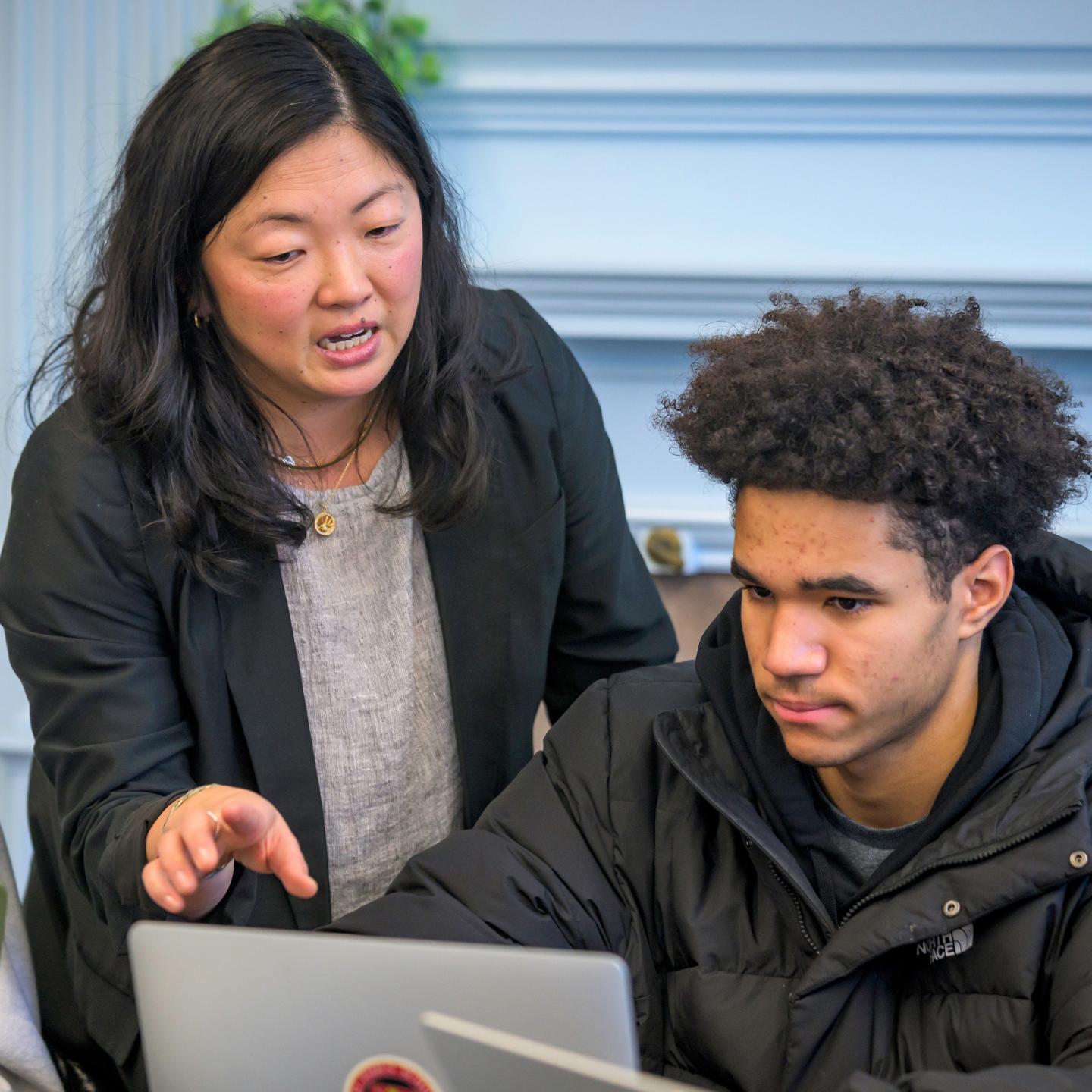 Humanities Teacher Beth Little works directly with a student in her Humanities III class in Schoolhouse.