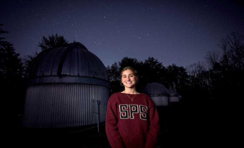 Emmerson Bentley '25, stands infront of the Hawley Observatory at SPS, where she spends much of her time looking at the stars.