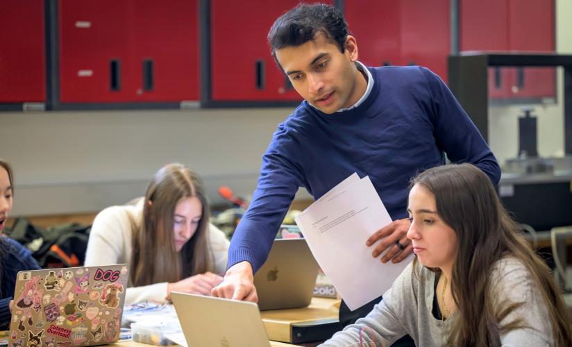 Computer Science Teacher Shreyas Rane reviews code with a student in his computer science class.