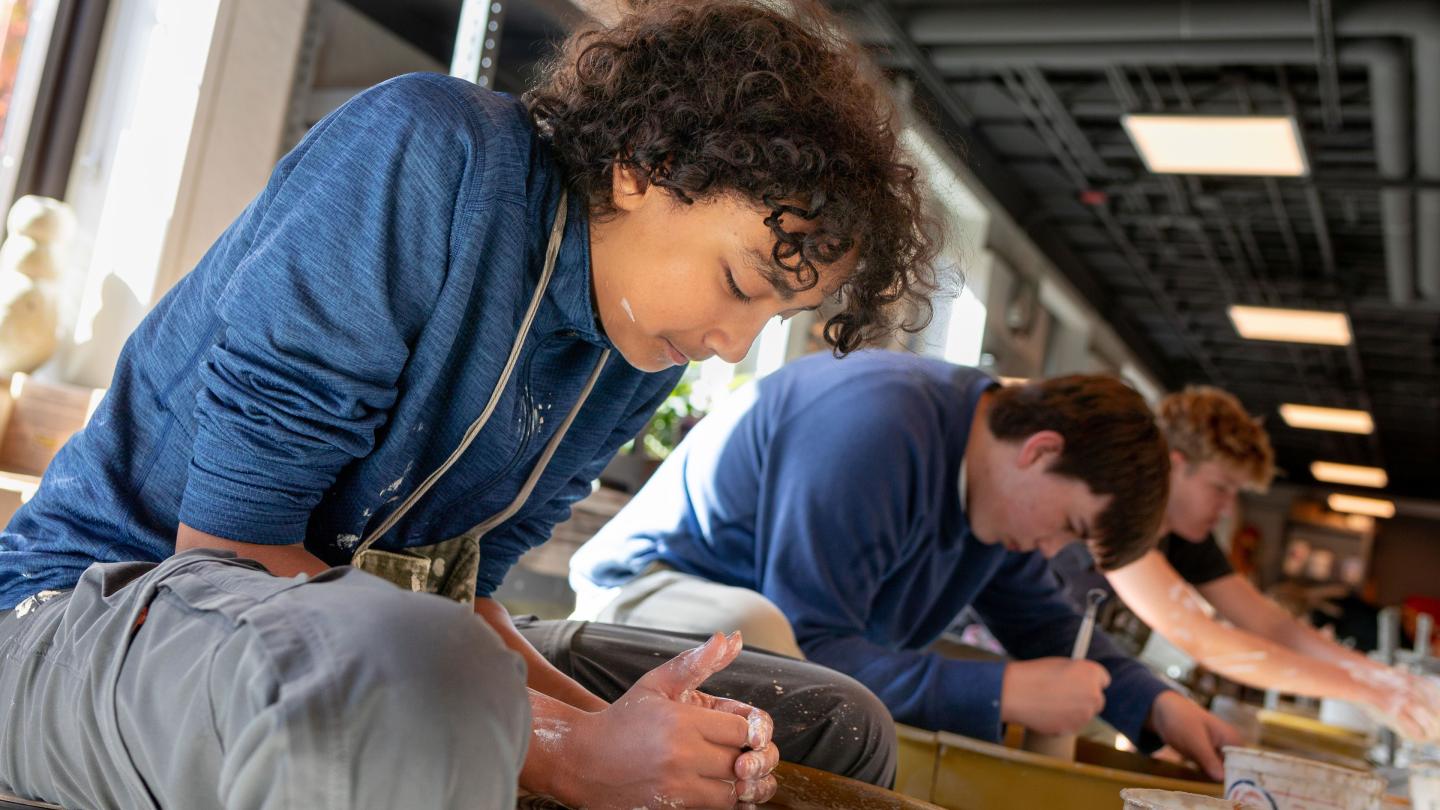 Students at the potters wheel in Ceramics class.