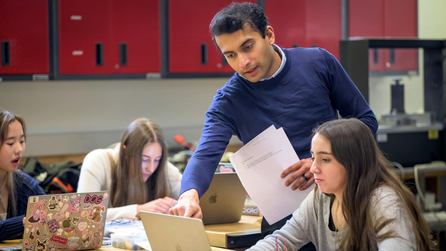 Computer Science Teacher Shreyas Rane reviews code with a student in his computer science class.