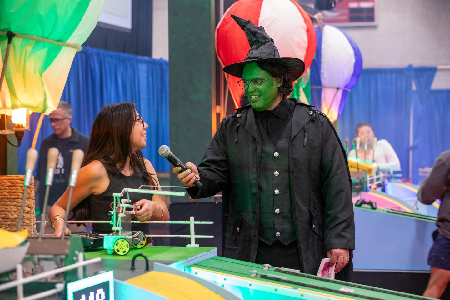 Amos Winter interviews a student at a robotics competition.